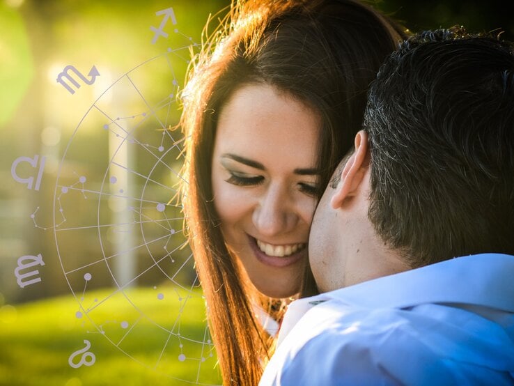 Ein lächelndes Paar in einer innigen Pose im Freien, beleuchtet von warmem Sonnenlicht. Im Hintergrund ist ein astrologisches Rad mit Symbolen der Tierkreiszeichen zu sehen, was auf eine Verbindung zur Astrologie und einem Flirthoroskop hinweist.