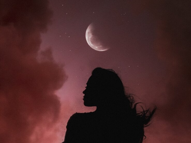 Silhouette einer Frau mit wehenden Haaren vor einem Nachthimmel mit rötlichen Wolken. Über ihr leuchtet ein zunehmender Halbmond, umgeben von kleinen Sternen. Die Szene wirkt mystisch und atmosphärisch.