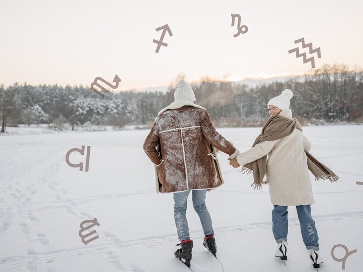 Ein verliebtes Paar hält sich an den Händen und läuft gemeinsam auf einem zugefrorenen See Schlittschuh. Beide tragen warme Winterkleidung – die Frau eine helle Jacke, eine Mütze und einen Schal, der Mann eine braune Lammfelljacke und eine Mütze. Der Schnee bedeckt ihre Kleidung, und ihre Spuren sind auf der eisigen Oberfläche sichtbar. Die Frau dreht sich mit einem glücklichen Lächeln zum Mann um. Der Hintergrund zeigt eine verschneite Winterlandschaft mit Bäumen und einem sanften Sonnenuntergang. Um das Paar schweben verschiedene astrologische Symbole, darunter für Schütze, Skorpion, Steinbock und Wassermann, was dem Bild eine mystische Note verleiht.