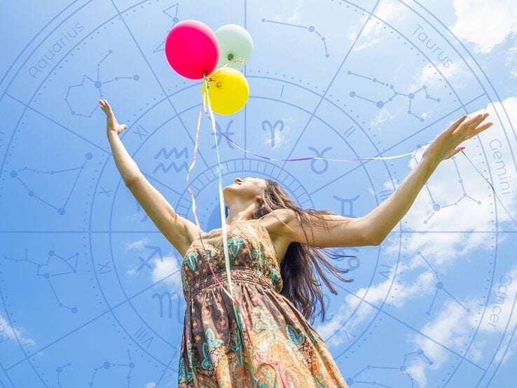 Frau in Sommerkleid hält bunte Luftballons in den Händen und blickt freudig in den Himmel, im Hintergrund ein transparenter Tierkreis mit Sternzeichen-Symbolen.