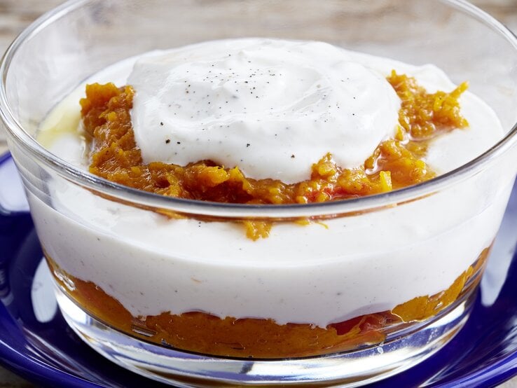 Nahaufnahme einer einer kleinen Glasschüssel mit dem Kürbis-Quark-Schichtdessert. 