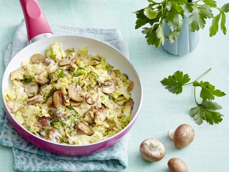 Das Pfannengericht auf einem hellblauen Tisch von schräg oben fotografiert.