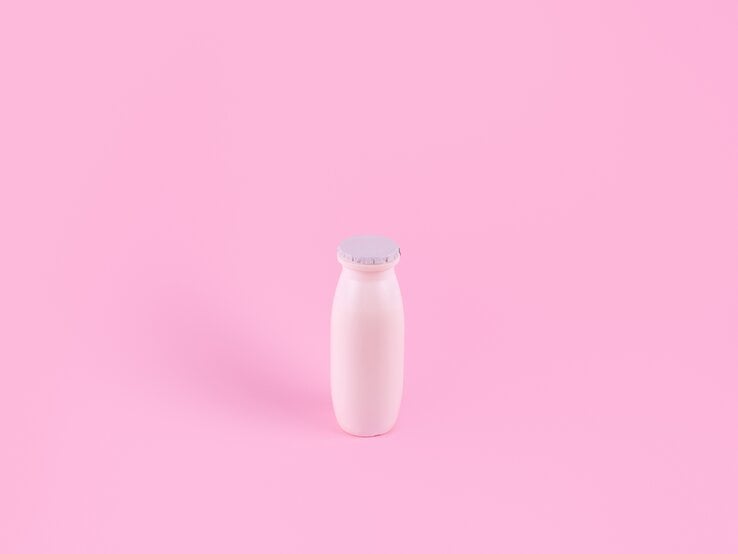 Actimel-Flasche auf rosa Hintergrund
