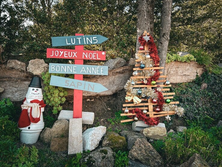 Zu sehen sind Richtungsschilder, die in einem Garten stehen.