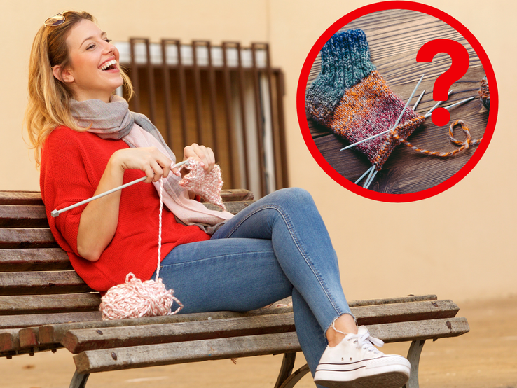 Junge Frau in rotem Pullover strickt lachend auf einer Parkbank, daneben ein Garnknäuel und ein Bild mit einer bunten Strickarbeit.