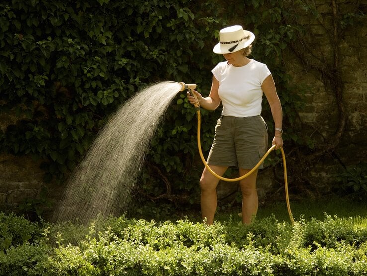 Frau wässert ihren Garten