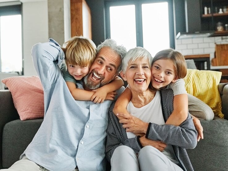 Zu sehen ist ein älteres Paar mit einem Jungen und einem Mädchen.