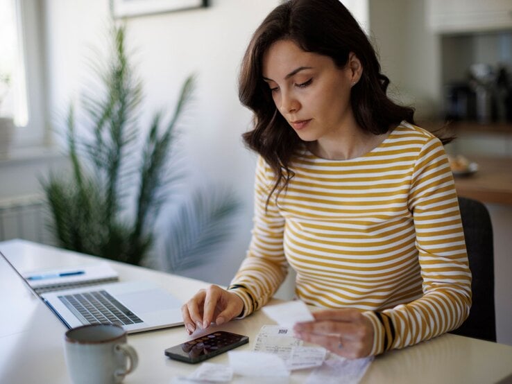 Eine Frau beschäftigt sich zuhause mit ihren Finanzen.