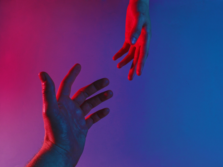 Zwei ausgestreckte Hände greifen nacheinander über ein zerrissenes Seil vor hellem Hintergrund.