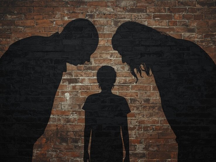 übergroße eltern als schattenbilder, die sich von links und rechts über die erwachsene tochter beugen. die ist kein schatten, wird von hinten gezeigt und ist etwas in sich eingesunken. thema: toxische eltern. als hintergrund eine backsteinwand