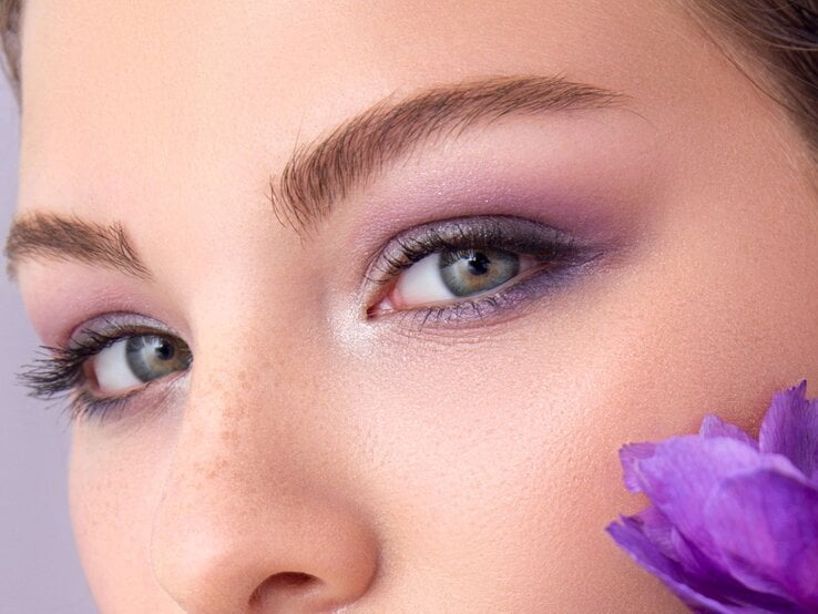 Zu sehen sind die Augen einer Frau mit Flieder-farbenden Lidschatten
