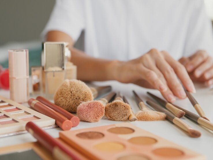 Zu sehen ist eine weibliche Hand, die ihre Schminke sortiert.
