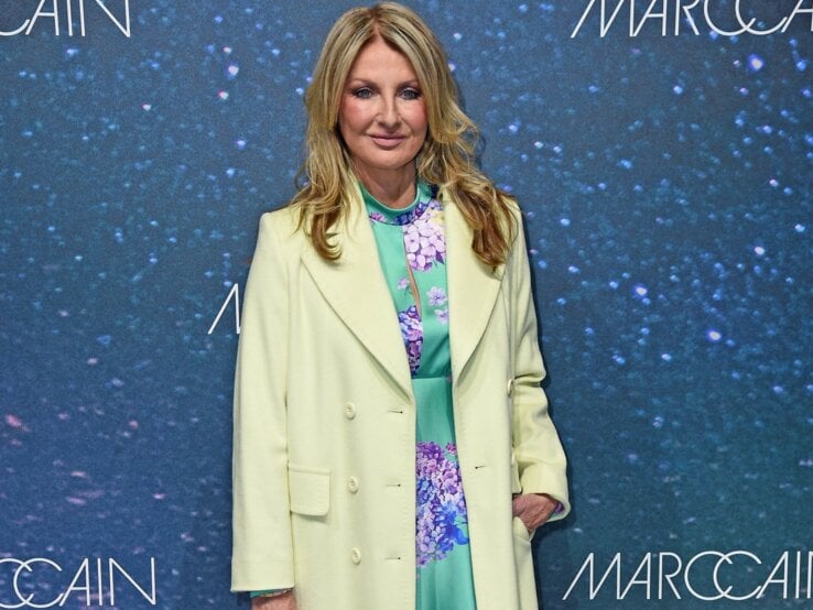 Elegant gekleidete Frauke Ludowig mit welligem, blondem Haar trägt ein mintgrünes Kleid mit floralem Muster, hellgrünen Mantel und nudefarbene Pumps.