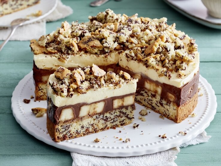 Schoko-Bananen-Torte auf einem weißen Tortenteller auf grünem Hintergrund.  | © EAT CLUB / Isabell Triemer