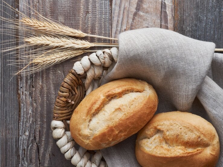 Zwei Brötchen im Brotkorb auf graubraunem Holz.  | © AdobeStock/tilialucida