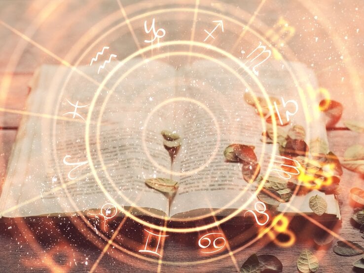 Ein altes, aufgeschlagenes Buch liegt auf einem Holztisch, umgeben von verstreuten, trockenen Blättern. Eine kleine Pflanze wächst aus den Seiten des Buches. Darüber ist ein leuchtendes astrologisches Rad mit den zwölf Tierkreiszeichen eingeblendet, das magisch und mystisch wirkt.