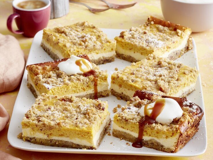Draufsicht auf sieben Stücke des Kürbis-Streuselkuchen auf einer Kaffeetafel. | © EAT CLUB/Isabell Triemer